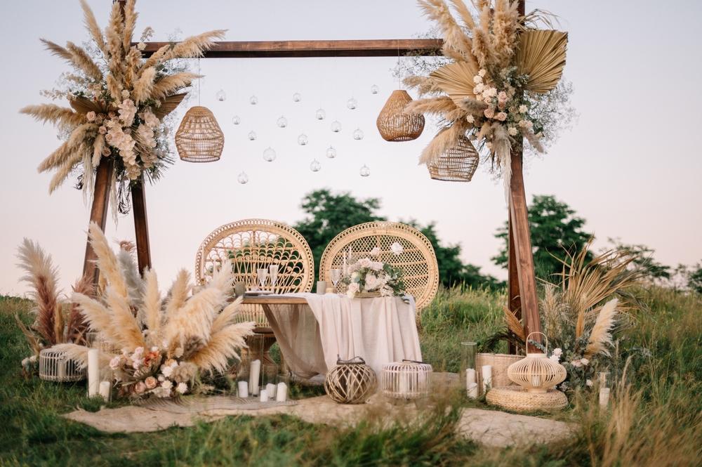 A place with palm trees and a dining table between them set there for an event