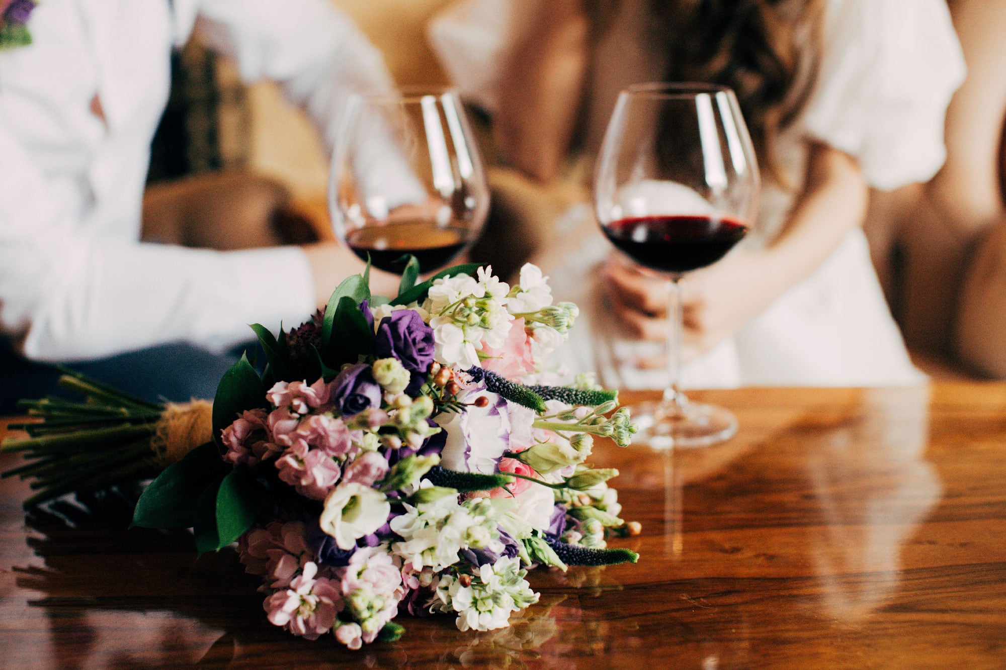 Wine drinks on a wood table with flowers chosen for the event